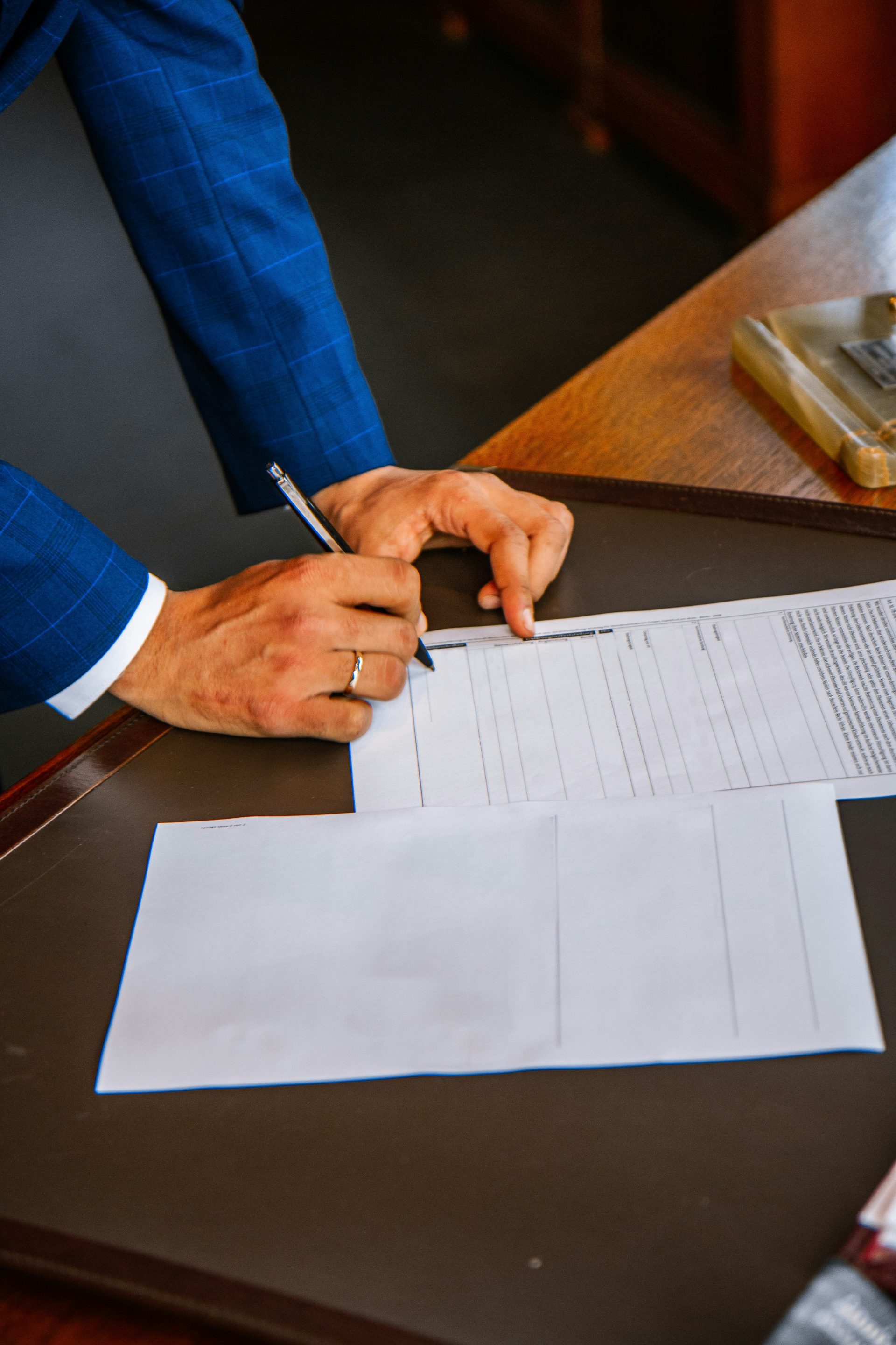 Person schreibt auf weißes Formularpapier
